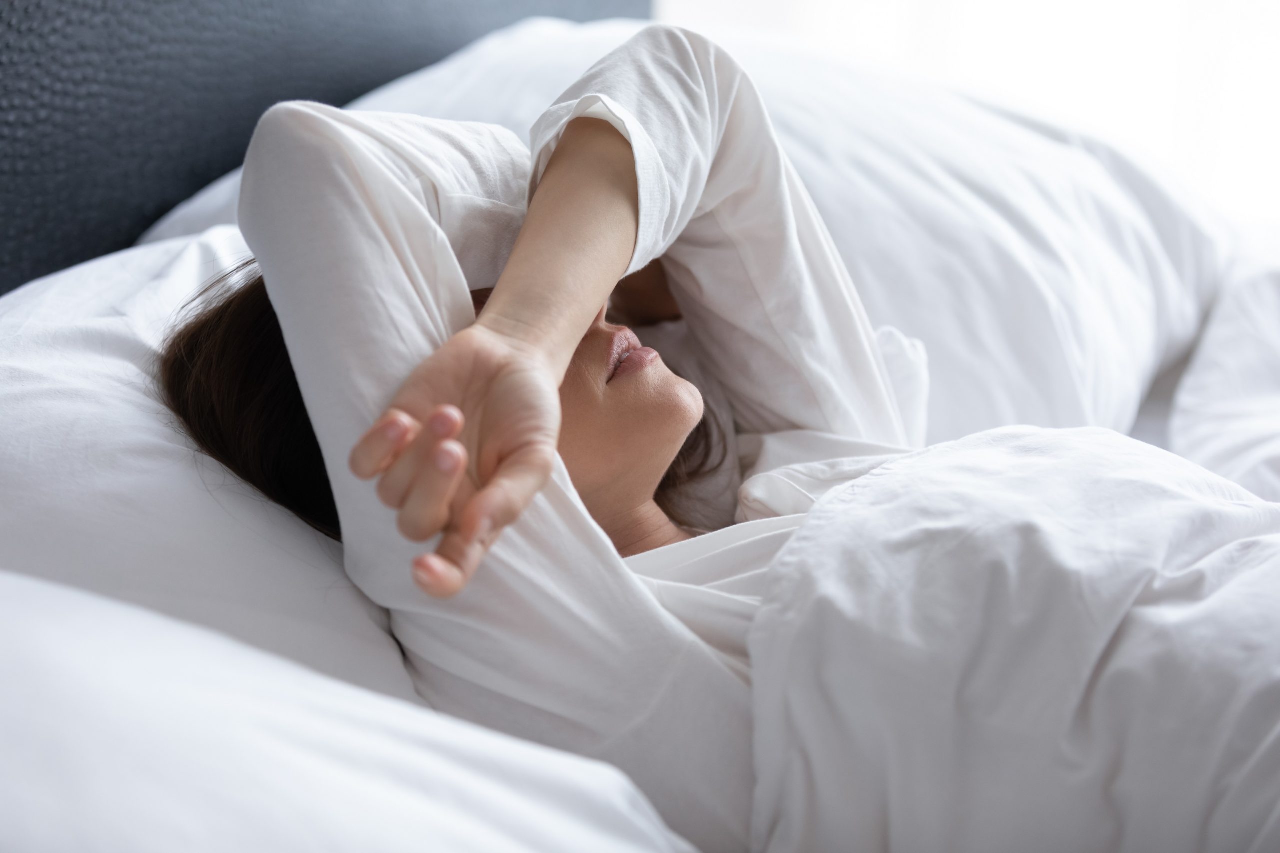 不眠症に悩むベッドに横になる女性