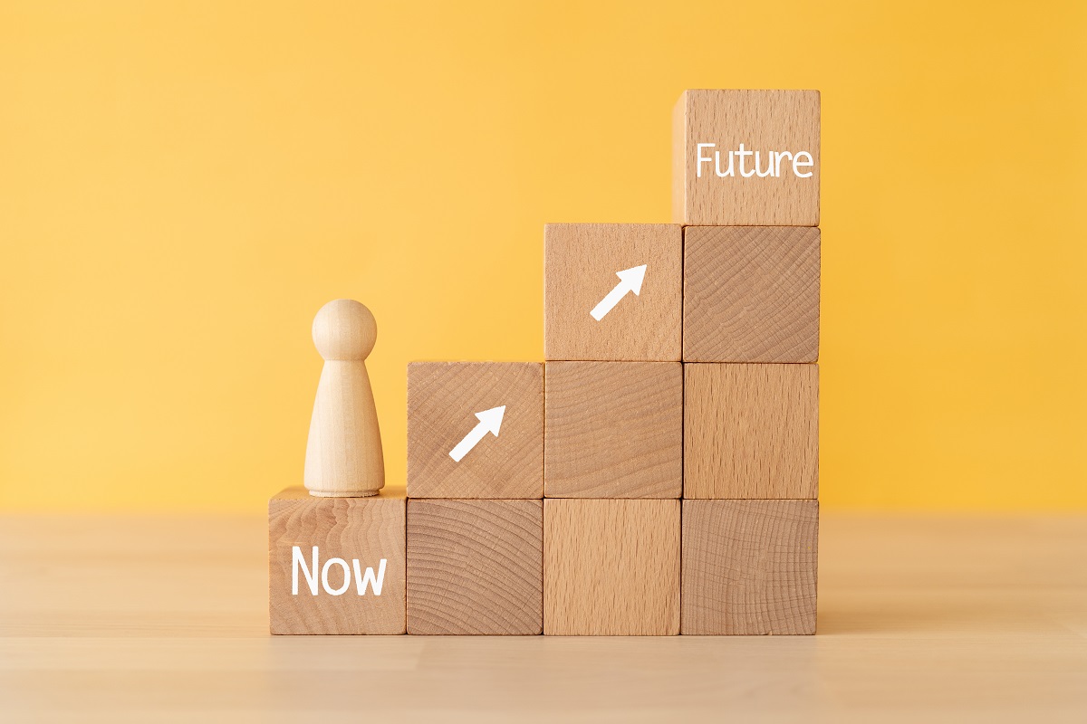 From now to the future; Wooden blocks with "Now" and "Future" text of concept and a human toy.